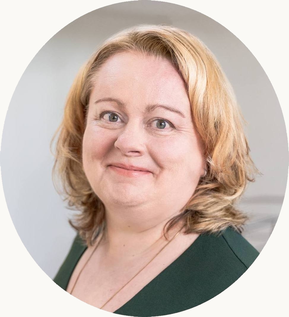 Kreisrundes Portrait von Eva Freyer in dunkelgrünem Oberteil vor hellem Hintergrund